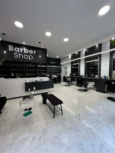 Το εσωτερικό του Hair Avenue με καθρέφτες, καρέκλες κουρέματος και ανοιχτόχρωμο πέτρινο δάπεδο